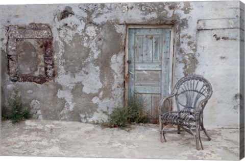 Framed Old Building chair and doorway in town of Oia, Santorini, Greece Print