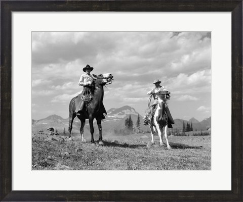 Framed Pair Of Cowboys On Horseback At Glacier Fifty Mountain Camp Print