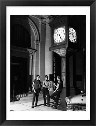 Framed Young men standing below clock at night Print