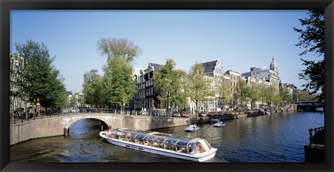 Framed Netherlands, Amsterdam, tour boat in channel Print