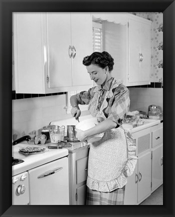 Framed 1950s Housewife In Kitchen Mixing Ingredients Print