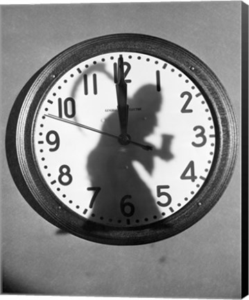 Framed Close-up of the shadow of a person carrying a scythe on a clock Print