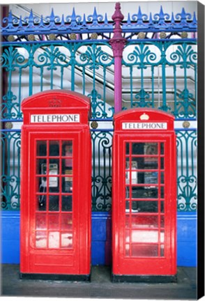 Framed Two telephone booths near a grille, London, England Print