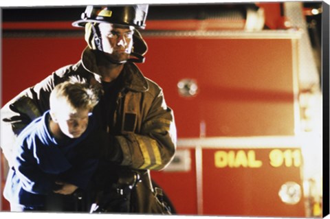 Framed Close-up of a firefighter carrying a boy Print