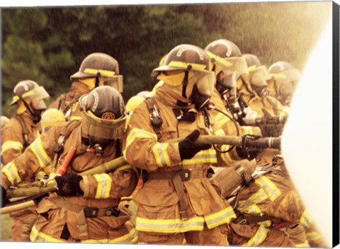 Framed Group of firefighters spraying water with a fire hose Print