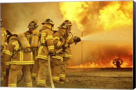 Framed Rear view of a group of firefighters extinguishing a fire Print