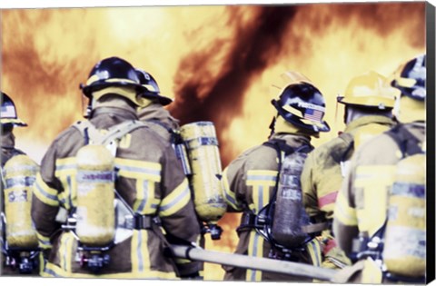 Framed Rear view of a group of firefighters holding water hoses Print