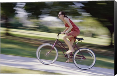 Framed Side profile of a young woman riding a bicycle Print