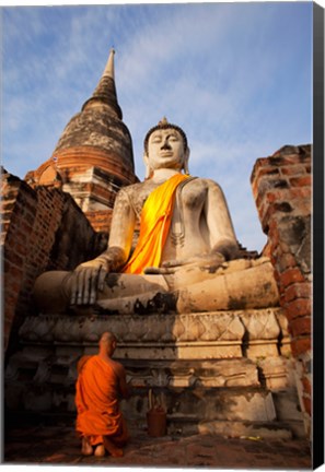 Framed Monk praying in front of a statue of Buddha Print