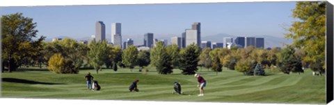 Framed Four people playing golf with buildings in the background, Denver, Colorado, USA Print