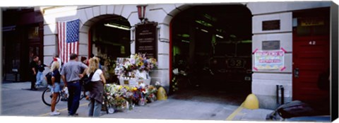 Framed Rear view of three people standing in front of a memorial at a fire station, New York City, New York State, USA Print