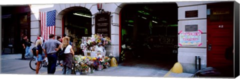 Framed Rear view of three people standing in front of a memorial at a fire station, New York City, New York State, USA Print