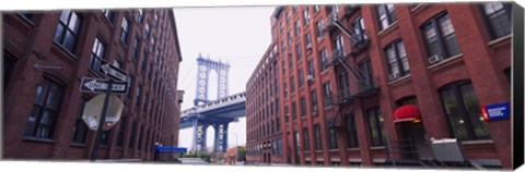 Framed Low angle view of a suspension bridge viewed through buildings, Manhattan Bridge, Brooklyn, New York City, New York State, USA Print