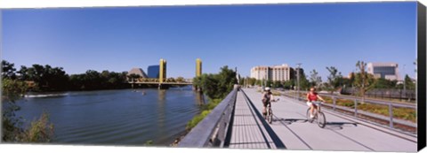 Framed Bicyclists along the Sacramento River with Tower Bridge in background, Sacramento, Sacramento County, California, USA Print