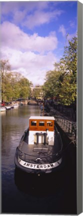 Framed Tourboat docked in a channel, Amsterdam, Netherlands Print