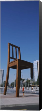 Framed Woman standing under a sculpture of large broken chair, Geneva, Switzerland Print