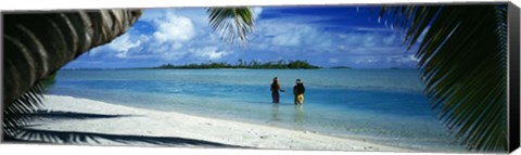 Framed Rear view of two native teenage girls in lagoon, framed by palm tree, Aitutaki, Cook Islands. Print