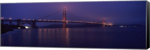 Framed Suspension bridge lit up at dawn viewed from fishing pier, Golden Gate Bridge, San Francisco Bay, San Francisco, California, USA Print