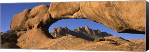 Framed Mountains viewed through a natural arch with a mother holding her baby, Spitzkoppe, Namib Desert, Namibia Print