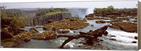 Framed Log on the rocks at the top of the Victoria Falls with Victoria Falls Bridge in the background, Zimbabwe Print