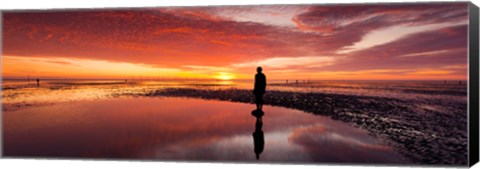 Framed Silhouette of human sculpture on the beach at sunset, Another Place, Crosby Beach, Merseyside, England Print