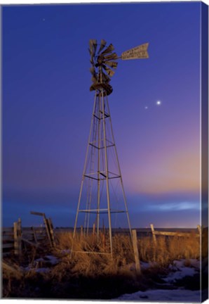 Framed Venus and Jupiter are visible behind an old farm water pump windmill, Alberta, Canada Print