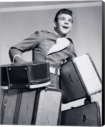 Framed 1950s Smiling Bellboy Carrying Four Bags Of Luggage Print