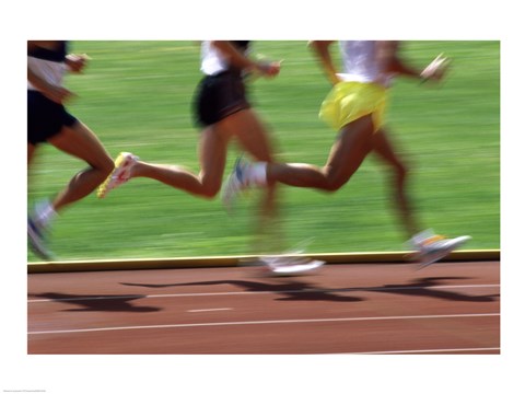 Framed Low section view of male athletes running on a running track Print