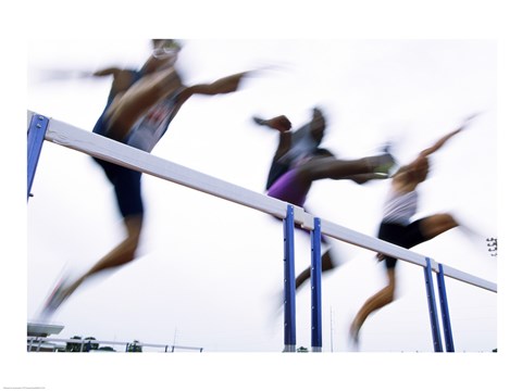 Framed Low angle view of three men jumping over a hurdle Print