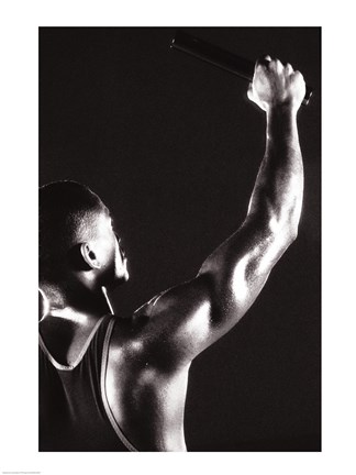 Framed Male runner holding up a relay baton Print
