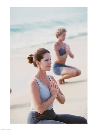 Framed Young woman and a mid adult woman meditating on the beach Print
