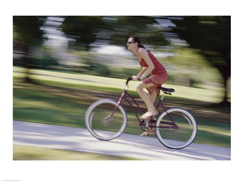 Framed Side profile of a young woman riding a bicycle Print