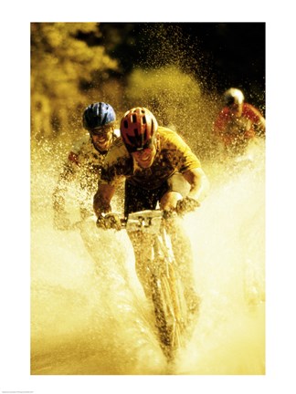 Framed Young men riding bicycles through water Print