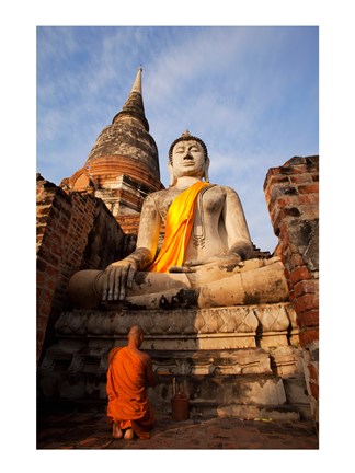 Framed Monk praying in front of a statue of Buddha Print