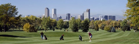 Framed Four people playing golf with buildings in the background, Denver, Colorado, USA Print