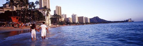 Framed Rear view of a couple wading on the beach, Waikiki Beach, Honolulu, Oahu, Hawaii, USA Print