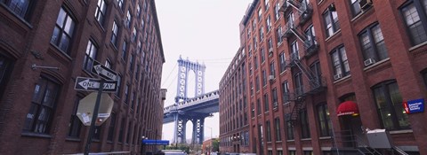 Framed Low angle view of a suspension bridge viewed through buildings, Manhattan Bridge, Brooklyn, New York City, New York State, USA Print