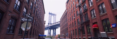 Framed Low angle view of a suspension bridge viewed through buildings, Manhattan Bridge, Brooklyn, New York City, New York State, USA Print