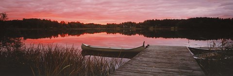 Framed Canoe tied to dock on a small lake at sunset, Sweden Print
