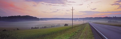 Framed Country road and telephone lines splitting farmlands at dawn, Finland Print