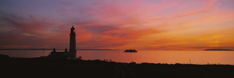 Framed Silhouette of a lighthouse at sunset, Scotland Print
