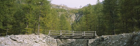 Framed Wooden footbridge across a stream in a mountain range, Switzerland Print