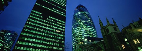 Framed Low angle view of buildings lit up at night, Sir Norman Foster Building, Swiss Re Tower, London, England Print