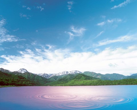 Framed Pink light cast down on two rings in lavender water with deep blue sky and clouds over green mountains in distance Print
