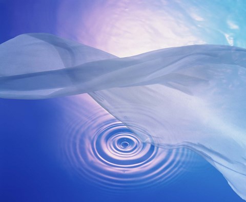 Framed Downward view of ring in lavender water with floating fabric in foreground and brightly lit background Print