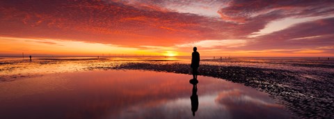 Framed Silhouette of human sculpture on the beach at sunset, Another Place, Crosby Beach, Merseyside, England Print