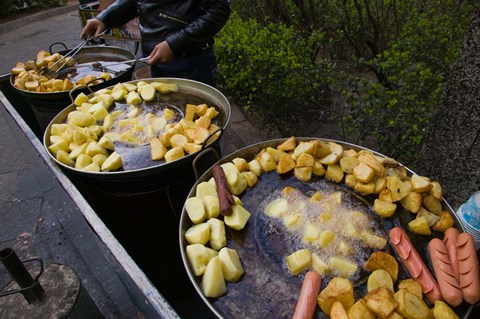 Framed Vendor selling deep fried potatoes and sausages at a sidewalk food stall, Old Town, Dali, Yunnan Province, China Print