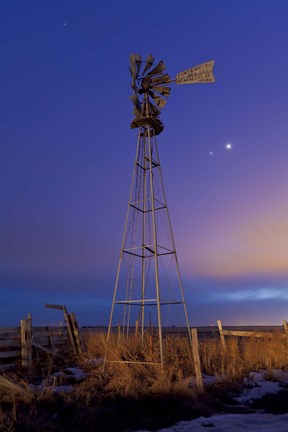 Framed Venus and Jupiter are visible behind an old farm water pump windmill, Alberta, Canada Print