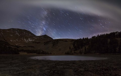 Framed Star trails and the blurred band of the Milky Way above a lake in the Eastern Sierra Nevada Print