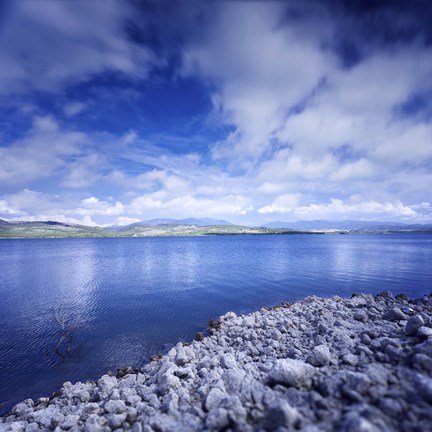 Framed Tranquil lake and rocky shore against cloudy sky, Sardinia, Italy Print